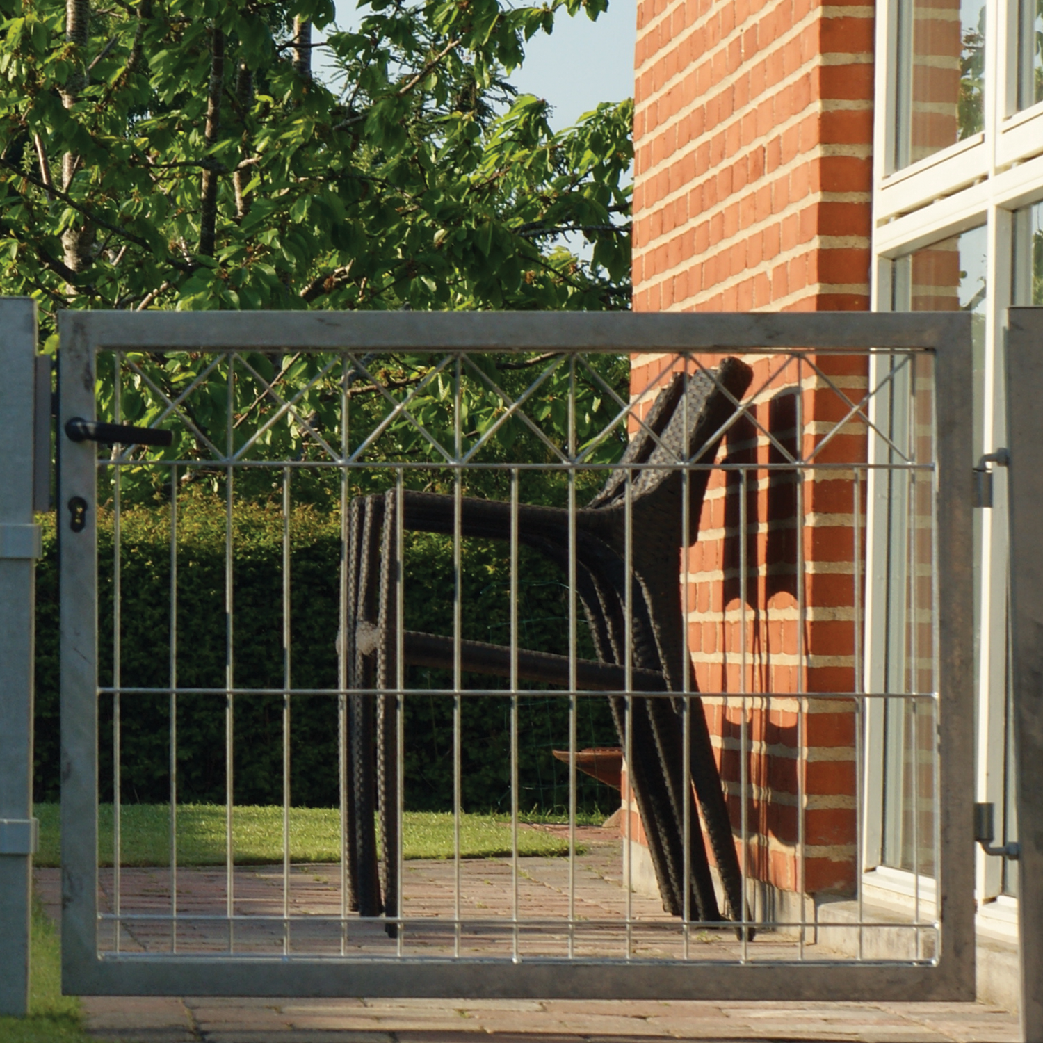 Galvaniseret metalhavelåge foran terrasse med stol