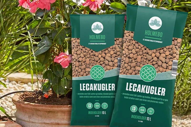 Holmebo Leca-kugler 10 L – lette dræningskugler til potter og planter To poser Holmebo Leca-kugler 10 L foran en havekrukke med blomstrende plante, vist som drænings- og jordforbedringsprodukt